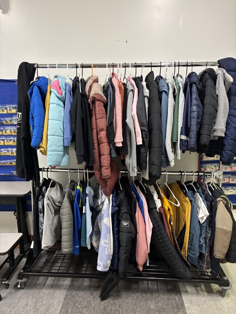 Two-level coat rack full of coats in various colors