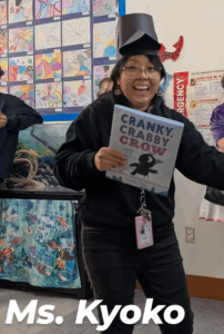 Ms. Kyoko wearing a crow hat holding Cranky, Crabby Crow