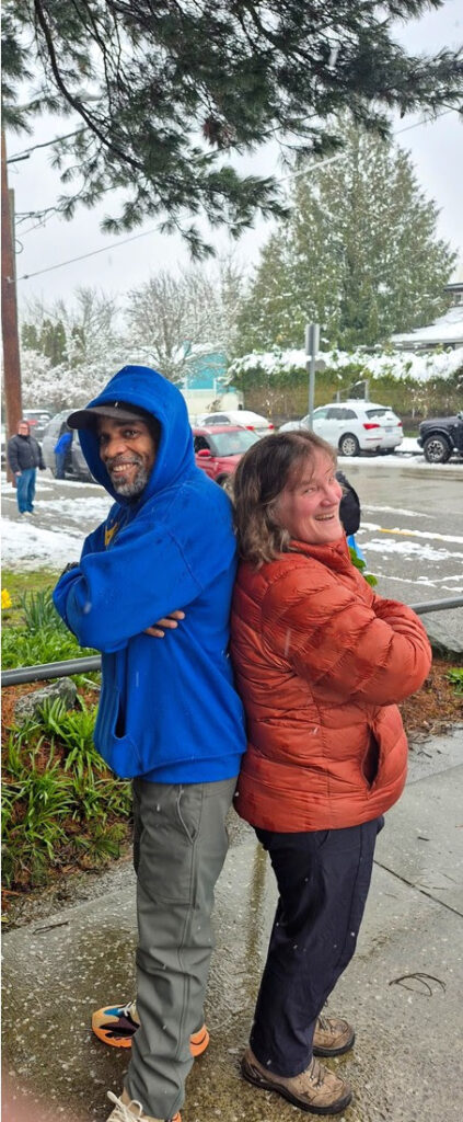 Mr. Hakeem and Nurse Ann smiling and standing back-to-back outside Roxhill